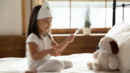 Little Asian girl act as nurse cure plush toy - obrazy, fototapety, plakaty