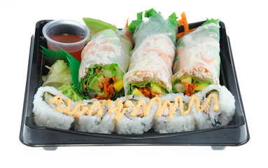 close up on fresh spring roll and sushi on black tray
