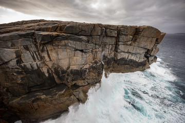 Dramatic early morning light and crashing waves at the Gap rock formation in Torndirrup National...