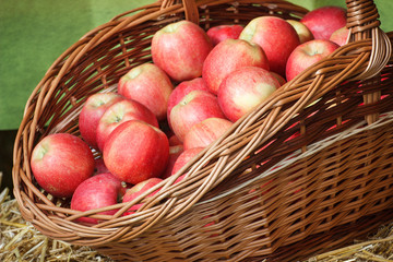 Fresh ripe apples in wicker basket on stall at bazaar