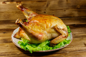 Baked whole chicken on a wooden table