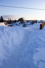 Wooden houses and fences covered with snow in Siberia, Russia.