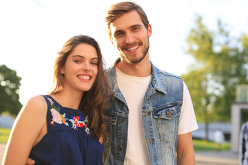 Obraz premium Image of lovely happy couple in summer clothes smiling and holding hands together while walking through city street.