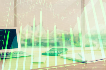 Forex graph hologram on table with computer background. Multi exposure. Concept of financial markets.