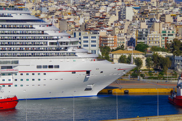 Huge cruiseship liner or cruise ship vessel with water slides and skyline of Athens in Greece while...