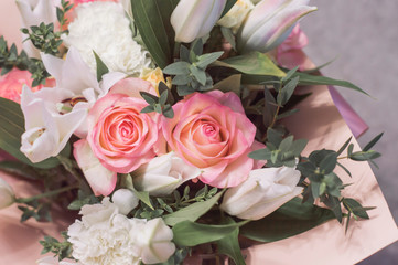 A bouquet of delicate flowers in close-up. Lilies, roses and carnations are white.