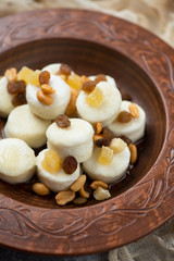 Close-up of steamed vareniki or curd dumplings served in a clay plate, vertical shot, selective focus