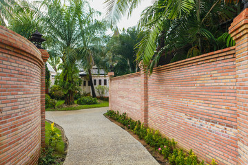 The walkway has flanked red brick walls in Phang Nga, Thailand.