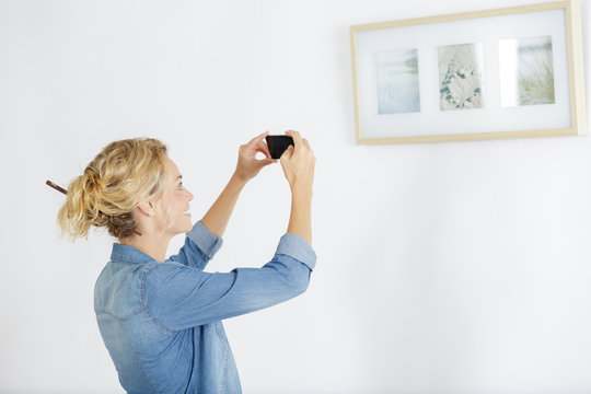 woman takes picture of paintings