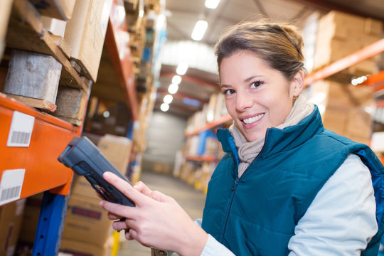 warehouse female worker scanning barcodes on boxes