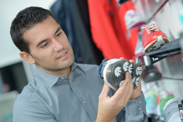 man looking at a golf shoe
