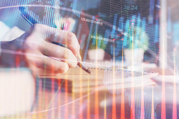 Financial forex charts displayed on woman's hand taking notes background. Concept of research. Double exposure