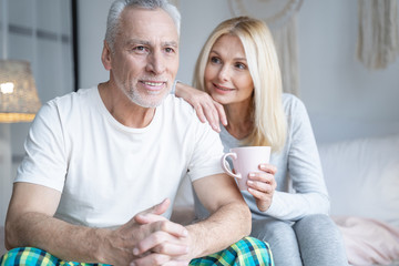 Happy man looking away and wife looking at him stock photo
