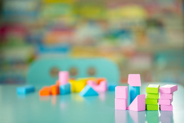 Multicolor wooden building blocks on blue table.