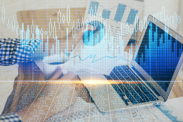 Obraz premium Double exposure of stock graph with businessman typing on computer in office on background. Concept of hard work.