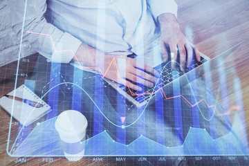 Forex graph with businessman working on computer in office on background. Concept of analysis. Double exposure.