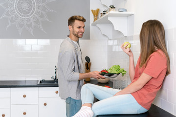 Young adult woman and man spending morning in kitchen