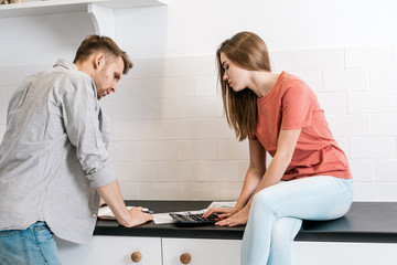 Fototapeta premium Young adult husband and wife spending morning in kitchen