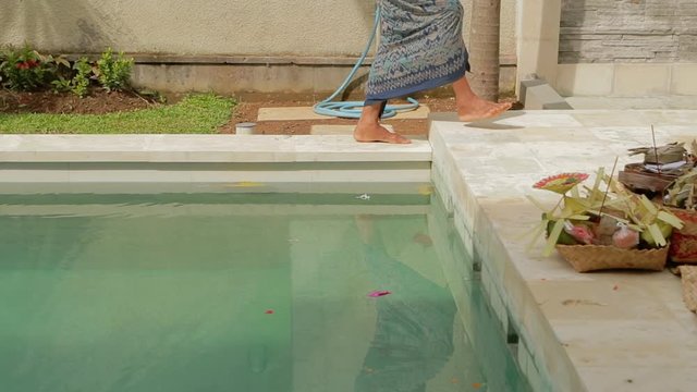 BALI INDONESIA - JANUARY 25 2019. Traditional indonesian hindu ceremony. Indonesian people celebrate pool construction. Women and men praying on the local villa. Tourism and travel concept