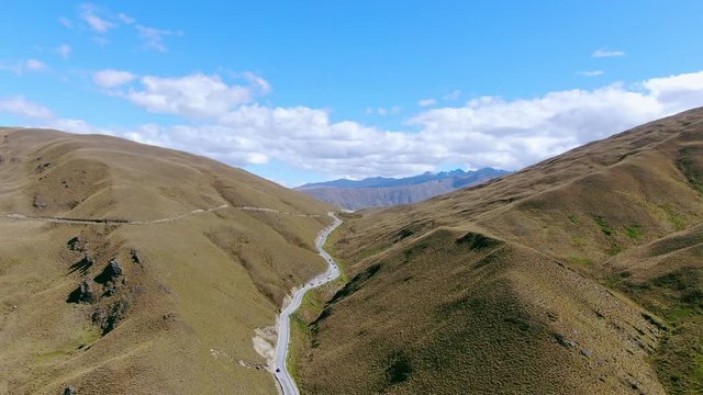 Stunning high angle aerial drone flight over the Crowns Range & the road passing through it near Cardrona, located between the popular tourist towns Queenstown & Wanaka on New Zealand's South Island.