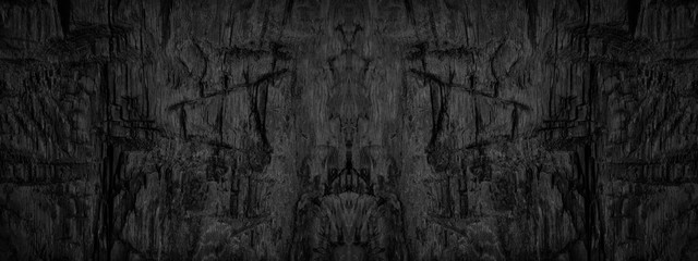 Black abstract grunge background. Burnt wooden surface with marks and nicks from an ax. Black and...