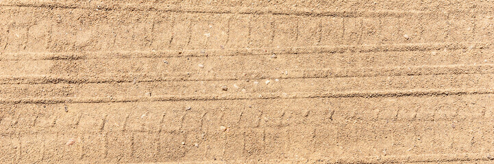 Panoramic image. Tire tracks on the sand. Sand texture
