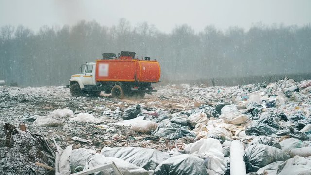A machine leaves junkyard with trash.