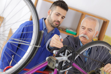 teen boy and grandfather fixing bike