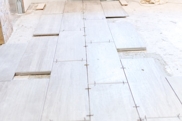 Close up shot of unfinished floor tiles installation in kitchen