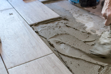 Close up shot of unfinished floor tiles installation in kitchen