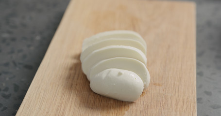 Closeup sliced fresh mozzarella on oak board