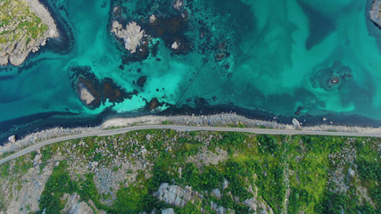 Top view of the road between the mountain with turquoise water in the bay between the Lofoten Islands
