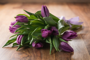 bunch of purple tulips on wood table
