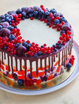 Bright festive cake with berries and chocolate on a white background