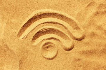 WiFi sign is painted on yellow sand, on the beach, on a summer sunny day. Top view. Background.
