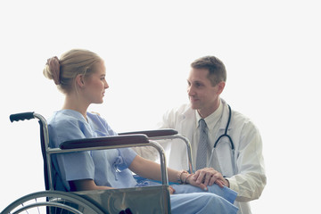 Obraz premium Doctor holding patient's hand who setting on wheelchair, doctor encourage and cheer up the patient to make her feel reassured and relaxed, health care and hospital concept