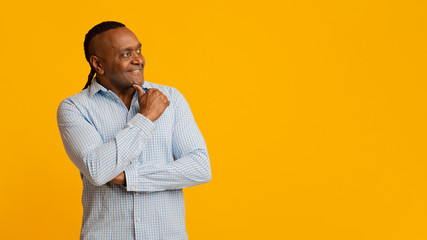 Cheerful pensive mature african man looking at empty space