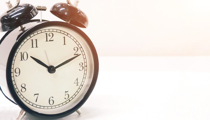 Closeup of an old classic black clock on white background for timing and planning in daily life and...