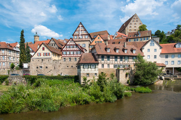 Fototapeta na wymiar Schwäbisch Hall, Germany - July 25, 2019; City view with half timbered houses on the waterfront of a touristic town on the romantic road in Bavaria