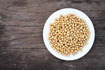 Soybeans in white dish on old wooden background, Top view
