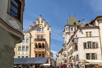 Market stands on the crossing of Via dei Portici / Piazza delle Erbe in Bolzano, South Tyrol, Italy - obrazy, fototapety, plakaty