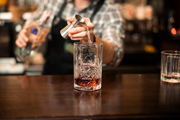 Bartender adding cocktail ingredients on whiskey cocktails