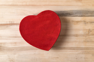 Fototapeta premium Vintage red heart shaped box on the brown wooden table. Gift for Valentine's day. Top view