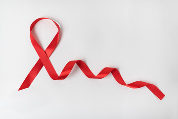 Obraz na płótnie Canvas Red ribbon on white background. Aid control symbol. Directly above