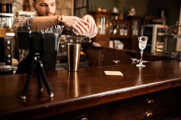 Young bartender is making video about cocktails