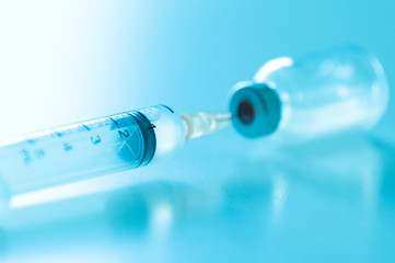 Closeup of flu, measles vaccine vials with syringe, medicine and drug concept