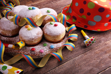 Carnival powdered sugar raised donuts with paper streamers. German berliner or krapfen for carnival