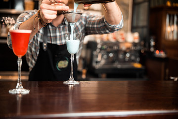 Bartender making white cocktail at bar counter
