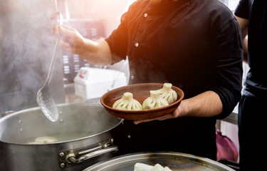 Chef coocking georgian khinkali or japanese wonton. Traditional meal 
