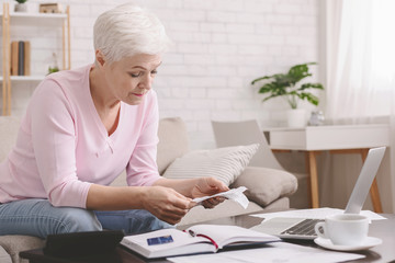 Senior lady counting finances and bills and home, empty space